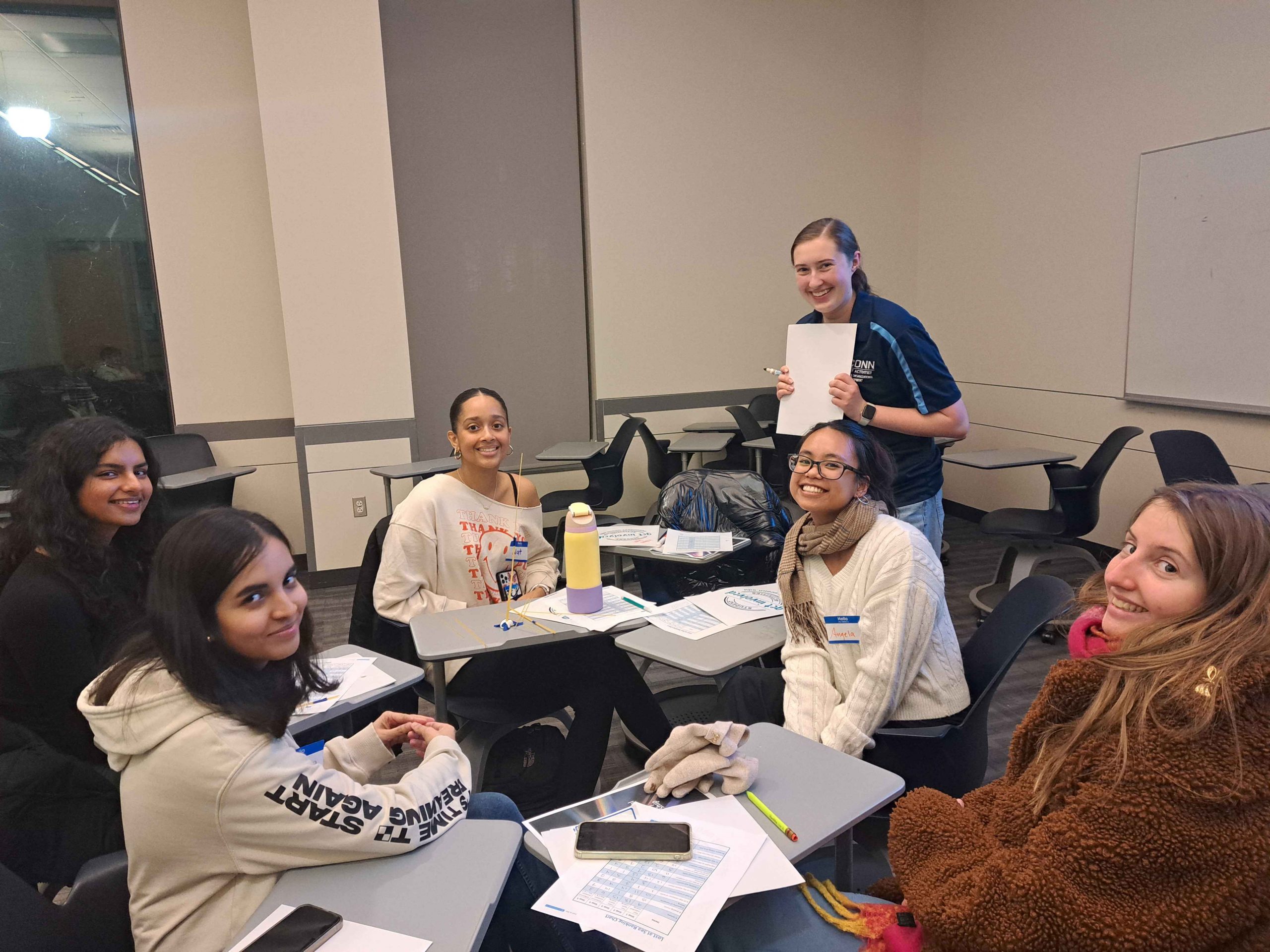 Students smile at camera during workshop discussion