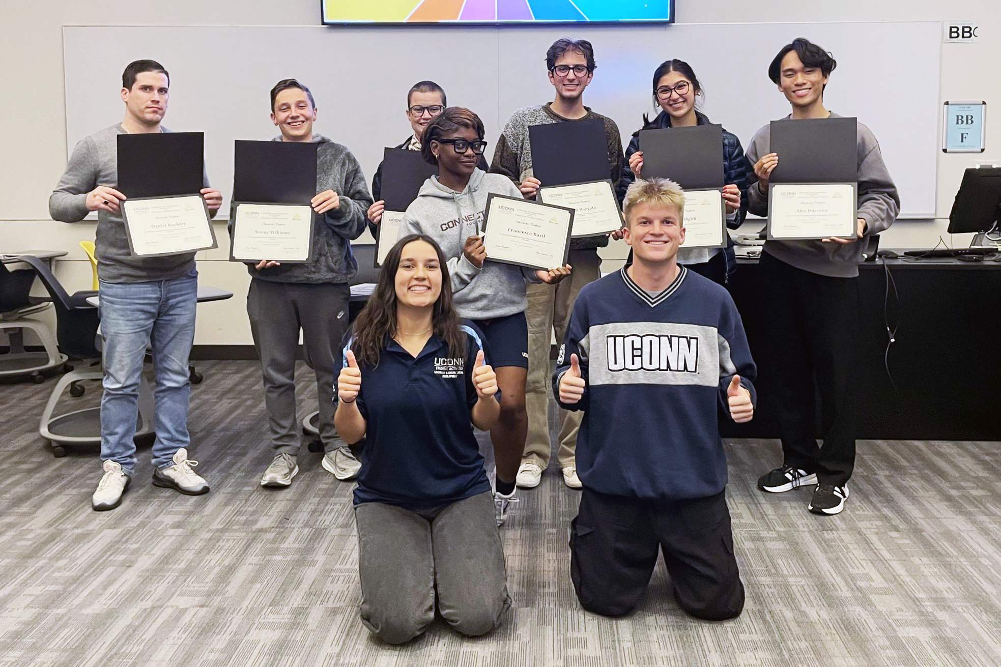 Students in workshop pose with certificates and facilitators 