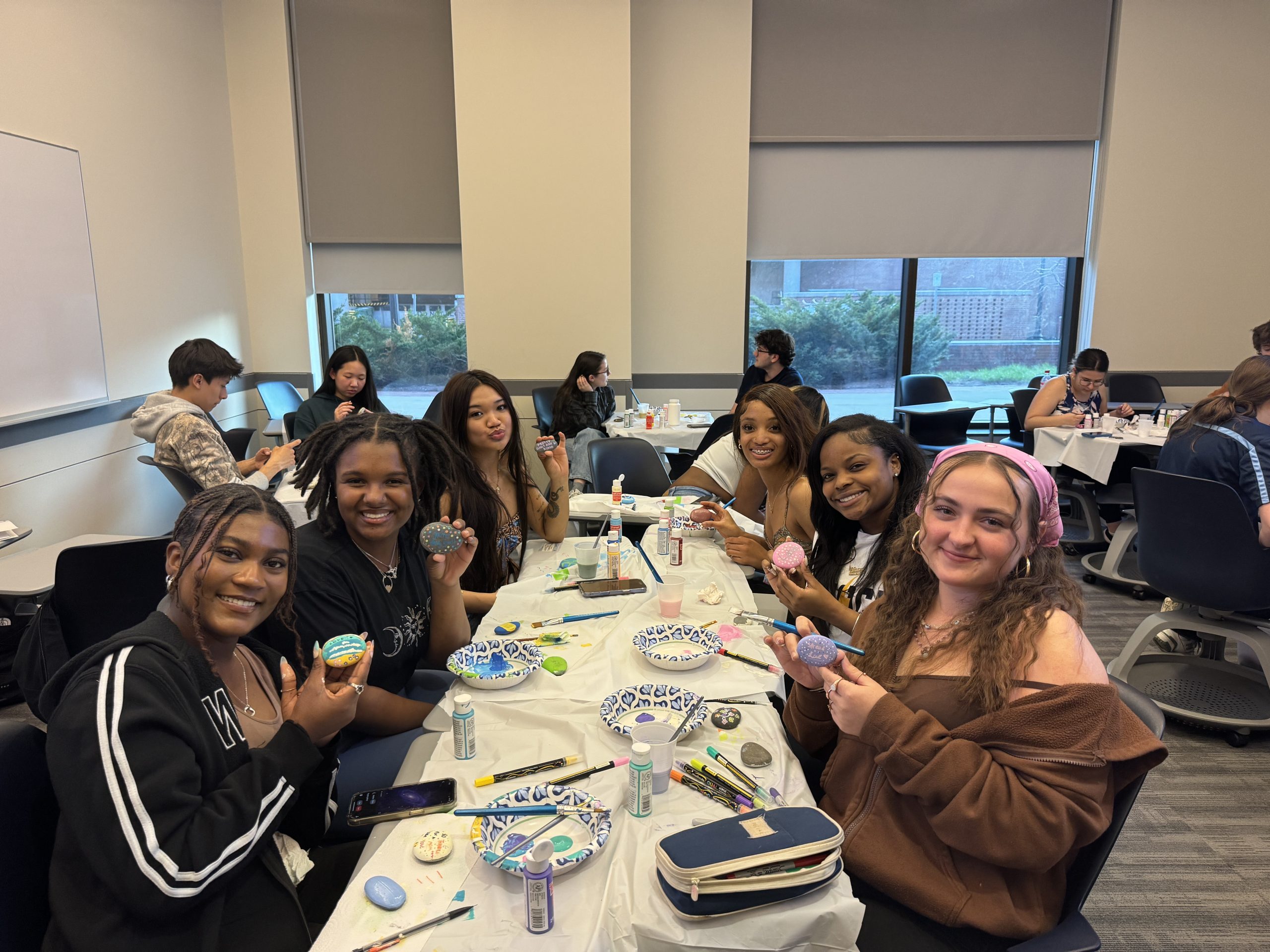 Students work on community service project together painting kindness rocks