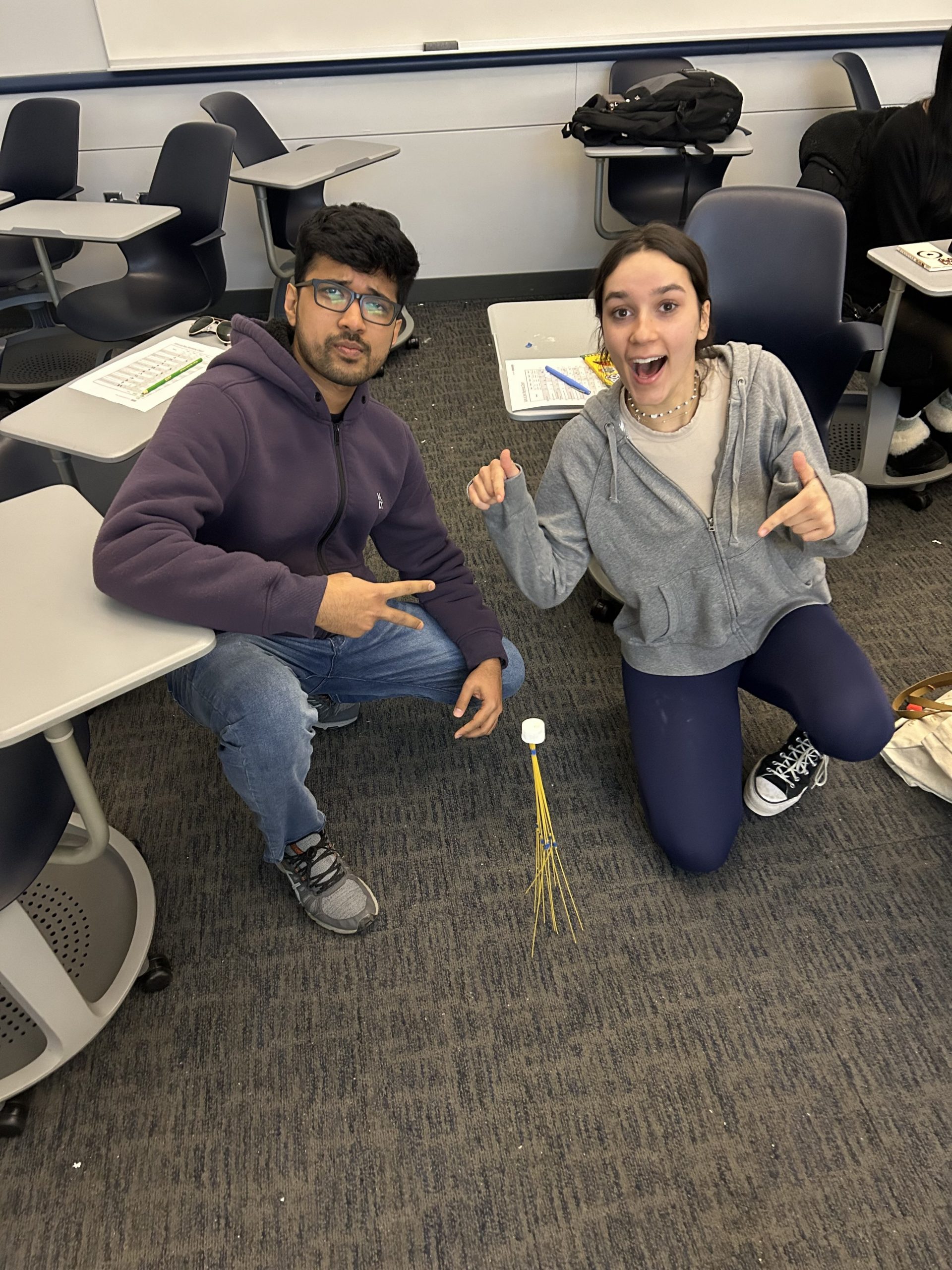 Students build spaghetti tower during activity together